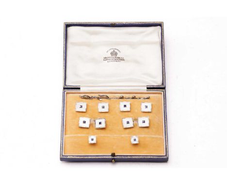 An Art Deco set of 18ct and enamel cufflinks and dress studs with blue sapphire centres, in fitted Mappin and Webb presentati