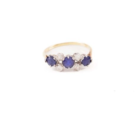 A sapphire and diamond dress ring, consisting of three round sapphires flanked by four old-cut diamonds, in a claw setting to