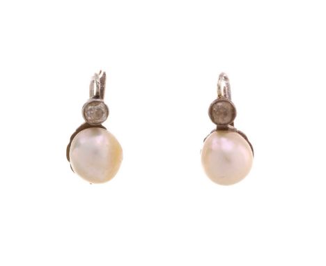 A pair of pearl and diamond earrings, each comprising a button-shaped cream-coloured pearl, approximately measures 8.5 mm, to