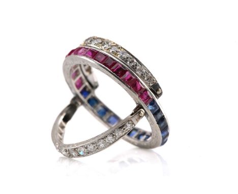 An Art Deco 'Night and Day' flip-over eternity ring, with half of the central band channel set with table-cut rubies and the 