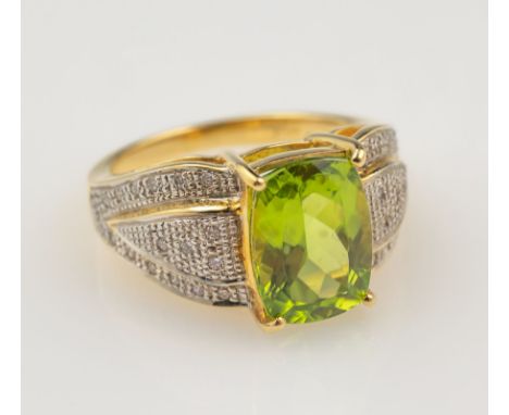 18 kt Gold Ring mit Peridot und Brillanten,  GG/WG 750/000, mittig facett. Peridot ca. 3.20ct, seitl. in WG gefasste 34 Brill