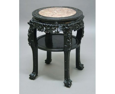 CHINESE HARDWOOD CIRCULAR OCCASIONAL TABLE OR STAND, pink marble inset top above a foliate pierced apron, lower shelf and cla