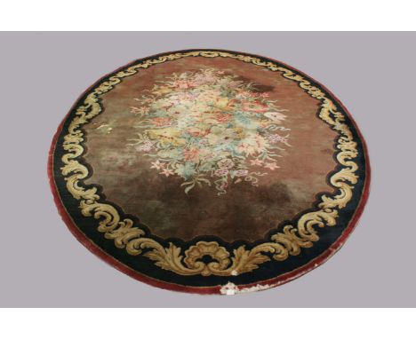 EUROPEAN OVAL CARPET, probably early 20th century, the chocolate field centred by a naturalistic floral spray enclosed by a b