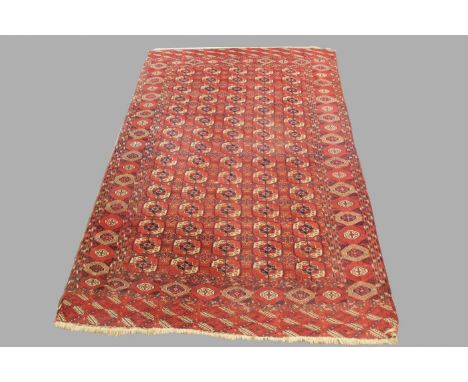 TEKKE TURKMEN CARPET, late 19th century, the madder field with five columns of quartered guls enclosed by hooked gul borders 