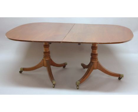 REGENCY STYLE MAHOGANY TWIN PEDESTAL DINING TABLE, the pair of D ends on tripod bases, with two extra leaves, max length 216c