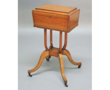 REGENCY SATINWOOD WORK BOX, early 19th century, the slightly fielded top enclosing a mirrored interior, on a scrolling quatri