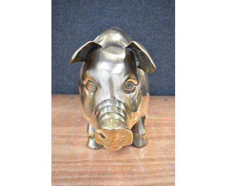 A vintage piggy bank of large size in brass approx 30cm tall and 50cm long.