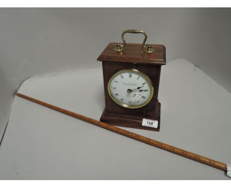 A Knight and Gibbins mahogany cased clock with a vintage yard measure stick