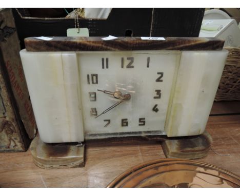 An Art Deco clock with stone cut body and classic design numerals