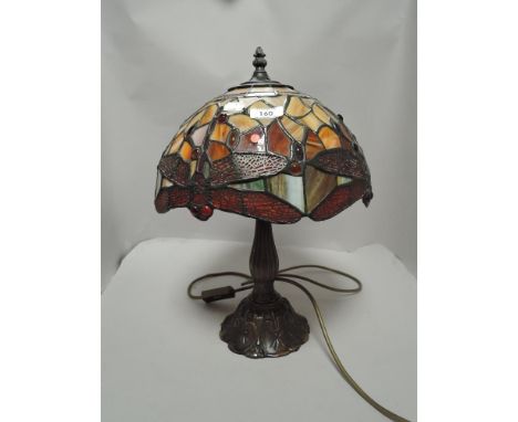 A modern Tiffany style leaded light lamp with dragonfly pattern shade and cast metal base