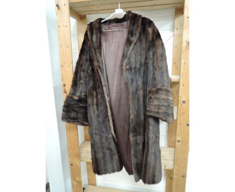 A vintage mid length fur coat in dark brown having wide cuffs.