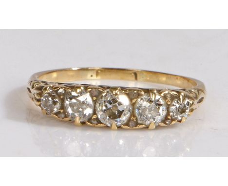 A five stone diamond ring, set with a graduated row of old brilliant cut diamonds and carved gallery, marks rubbed, 3.05 gram