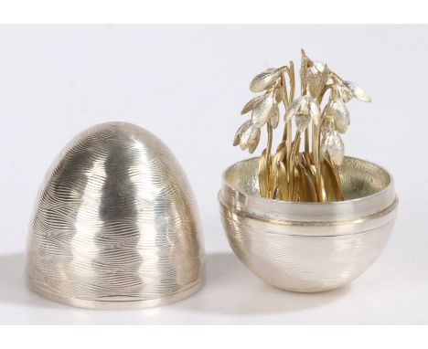 Nicholas Plummer silver "surprise" egg in the manner of Stuart Devlin, London 2004, the wavy lined engine turned egg with lif