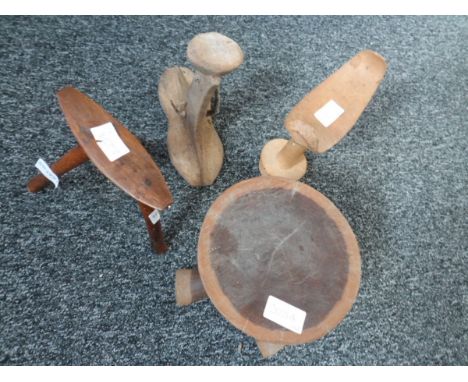 A collection of African tribal wooden headrests, some of pedestal form, some with tripod base 