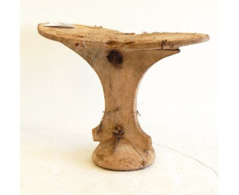 A collection of African tribal wooden headrests, some of pedestal form, some with tripod base 