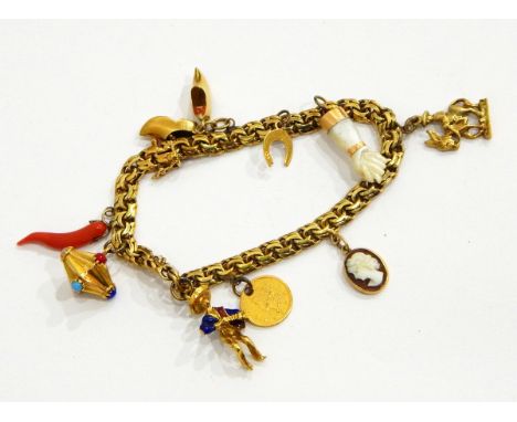 A charm bracelet marked 14ct with assorted charms including an enamelled figure of an accordion player, a piece of coral, etc