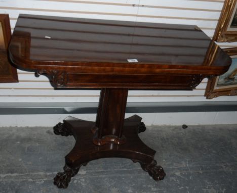 A Victorian mahogany fold-over card table raised on square tapering column with quatrefoil base and carved paw feet 