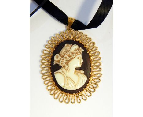 A cameo pendant of female portrait with gold-coloured wrigglework frame and a large silver and Sri Lankan topaz ring set oval