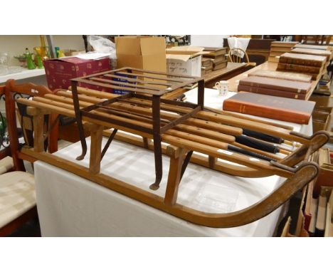 A vintage wooden sledge and a metal footman 