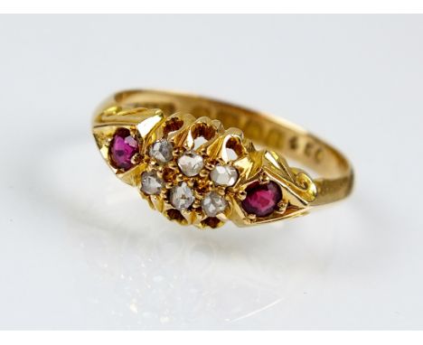 A George V 18ct gold diamond and ruby ring, designed as two rows of three rose cut diamonds flanked to each side by a round m