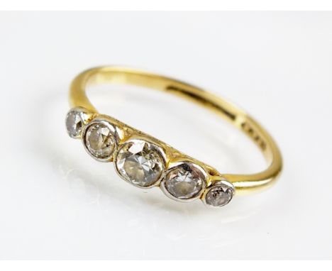An early 20th century graduated five stone diamond ring, the old cut diamonds collet set in white metal to yellow metal shank
