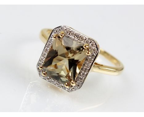 An 18ct gold csarite and diamond cluster ring, designed as a central rectangular faceted csarite claw set within a border of 