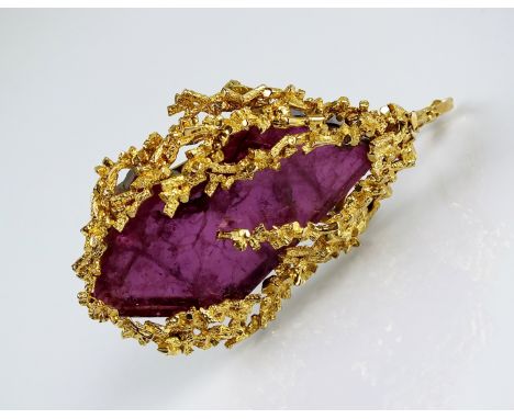 A 9ct gold abstract amethyst pendant/brooch, designed as large partially polished rough amethyst within textured bark finish 
