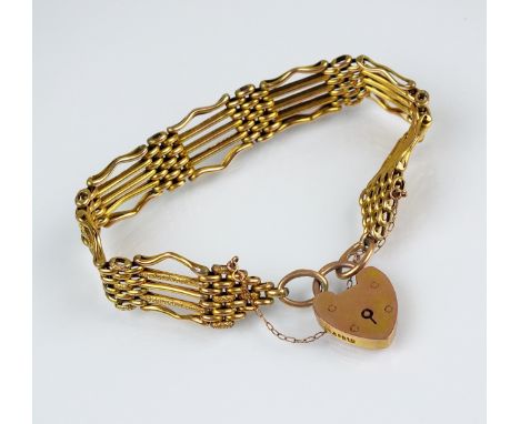 A 9ct yellow gold gate link bracelet, the five bar textured and plain polished link bracelet with heart shaped padlock clasp 