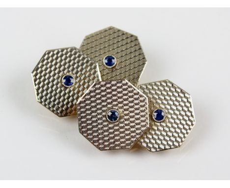 A pair of Art Deco sapphire set cufflinks, each designed as white metal engine turned octagonal links with central faceted sa