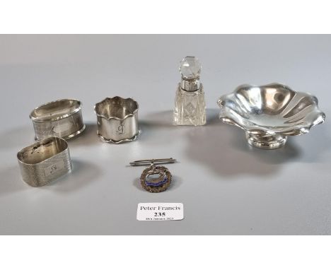 Small silver bonbon dish together with three silver napkin rings, a silver topped and glass dressing table/scent bottle and a