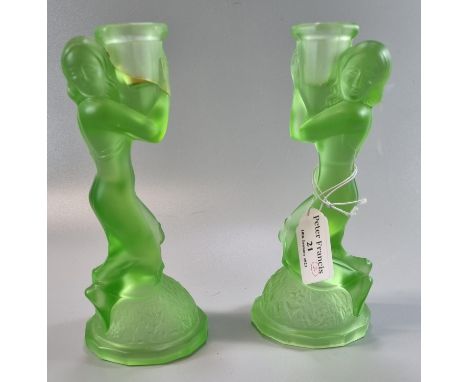 Pair of Art Deco uranium green moulded glass candle sticks decorated with female figures on a naturalistic base.  Height 19cm