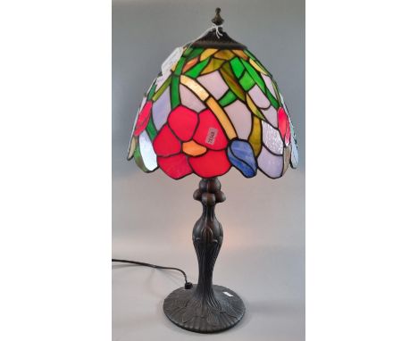 Tiffany style table lamp with multicoloured floral and foliate shade on a naturalistic circular base.  (B.P. 21% + VAT) 