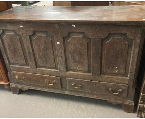 18th century Welsh oak coffer, the moulded top above four fielded panels, two fitted drawers on a projecting base and bracket