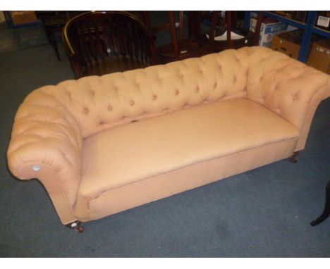 A Cottage Chesterfield sofa,  upholstered in salmon pink fabric with mahogany turned legs to front.