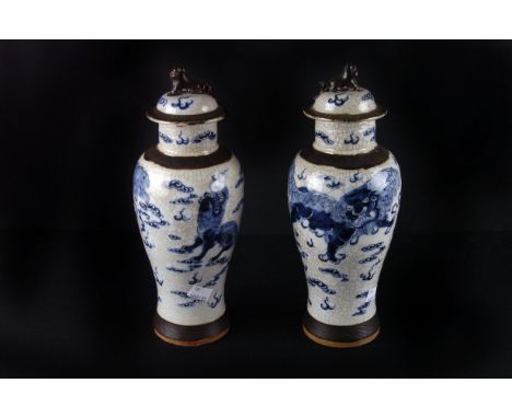 Two pairs of 19th century Chinese crackle-glaze covered vases,  of two sizes, each with lion finials, and moulded faux-bronze