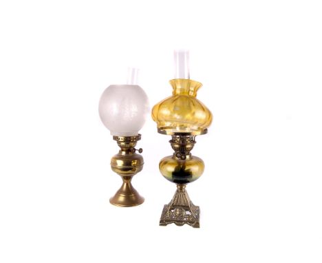 A 19th century parafin lamp, with glass shade and reservoir, on a cast brass base, together with another (2)