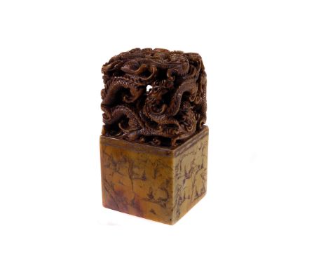 A Chinese carved soapstone scroll weight, of rectangular form, the top ornately pierced with a tangle of dragons, the lower h