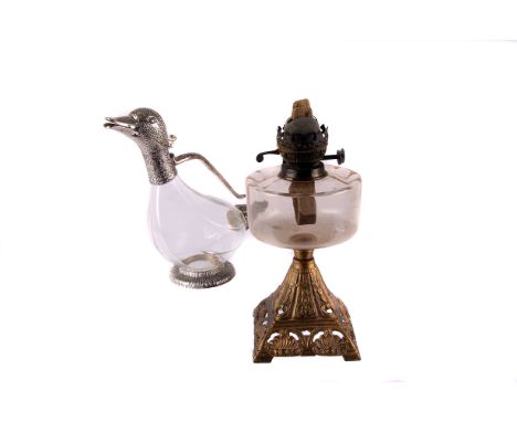 A 19th century paraffin lamp,  with clear glass reservoir, supported by a gilt metal base, together with a silver plate mount