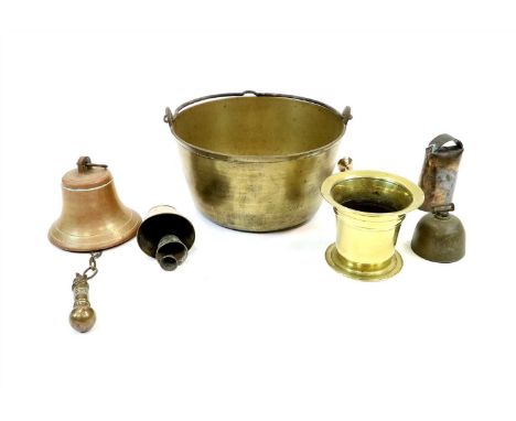 A Victorian brass mortar and pestle, an early 20th century bell, 14 cm high, three old cattle bells and a brass jam pan.