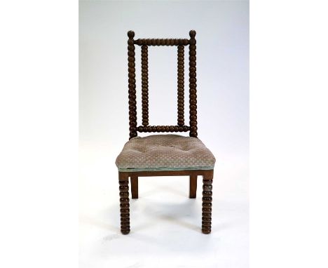 A Victorian turned rosewood bobbin nursing chair, the turned back bars terminating in polished globular knops, above an uphol