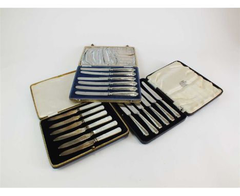 Two cased sets of six silver handled side knives, Sheffield, together with a cased set of six mother of pearl handled silver 