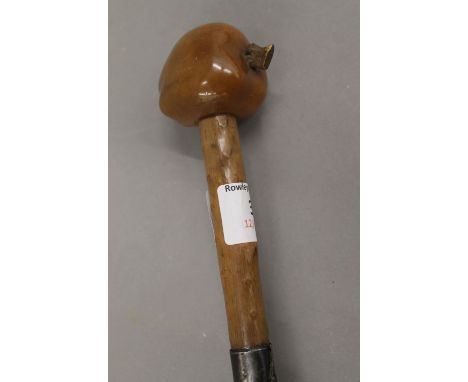 A silvered collared walking stick with carved nut form handle. 86 cm long.