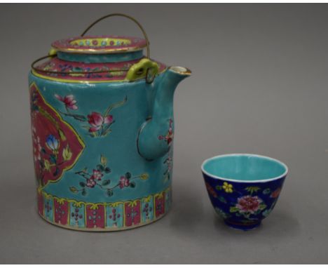A Chinese Peranakan Nyonya ware teapot and tea bowl in basket. 28 cm wide overall.