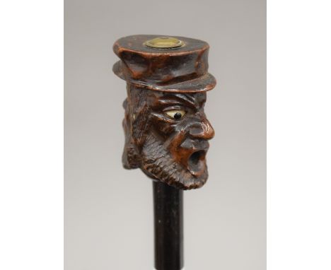 An ebony walking stick with carved wooden double head handle. 86 cm long.