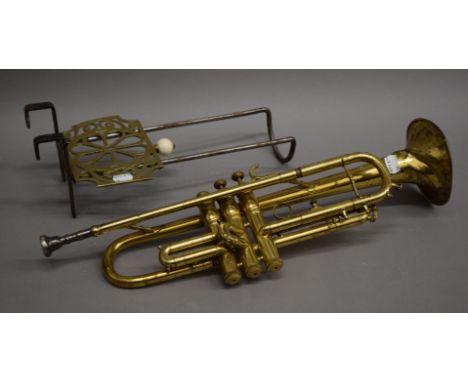 A vintage brass trumpet and a 19th century brass and steel trivet.