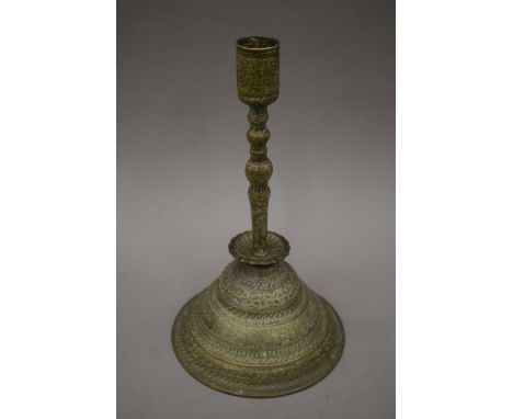 An antique Islamic brass candlestick. 34 cm high.