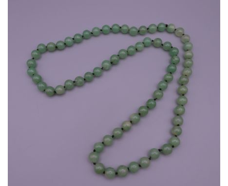 A string of jade beads. 89 cm long.