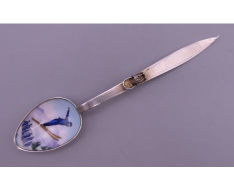 An 800 silver and enamel spoon, the bowl decorated with a ski jumper, the handle formed as a ski. 12.5 cm long.