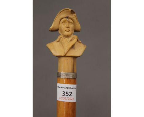 A walking stick, the carved wooden handle formed as a Napoleon. 93 cm long.