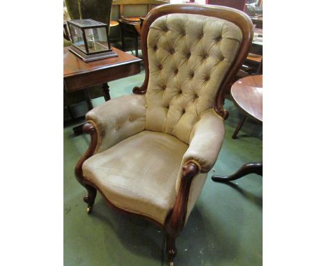 A circa 1840 mahogany spoon back armchair with scroll arms and legs, on brass castors